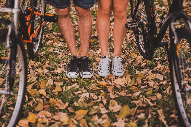 Obuwie zdrowotne na jesień 2023 Zdjęcie przedstawia parę w trampkach stoją obok rowerów